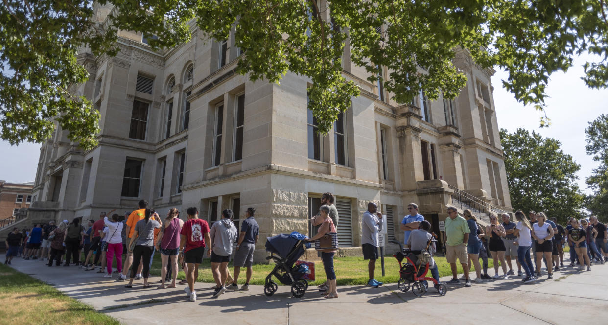 A long line of voters wraps around the Sedgwick County Historic Courthouse in Wichita, Kan., on the last day of early voting on Monday, Aug. 1, 2022. (Travis Heying/The Wichita Eagle via AP)