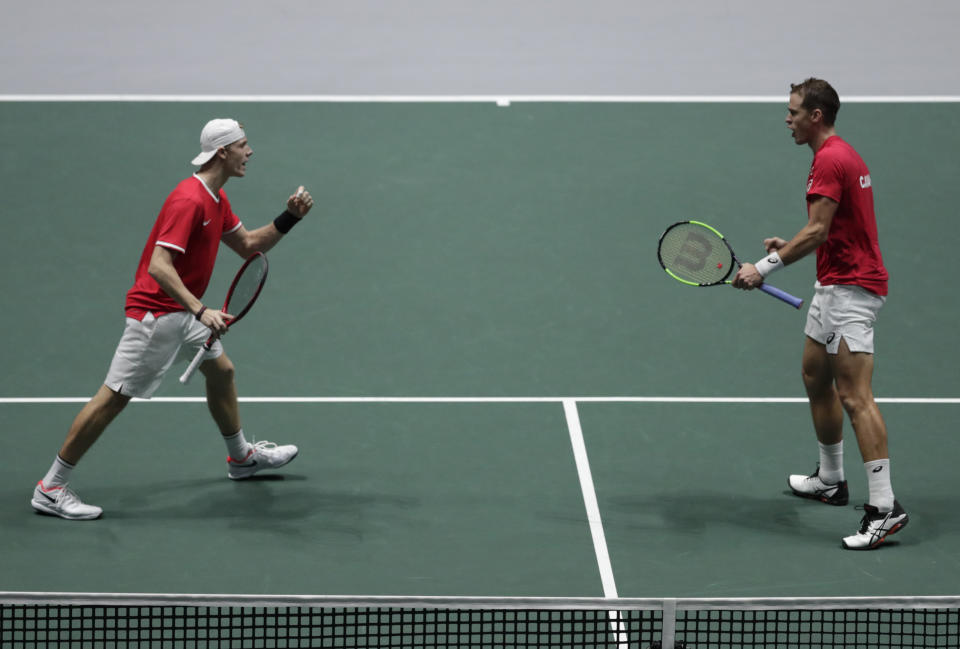 Los canadienses Denis Shapovalov (izquierda) y Vasek Pospisil celebran durante su partido de la Copa Davis contra el equipo ruso conformado por Karen Khachanov y Andrey Rublev, en Madrid, el sábado 23 de noviembre de 2019. (AP Foto/Bernat Armangue)