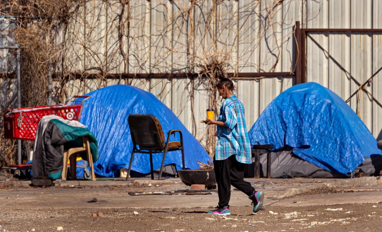 A person is seen walking past a homeless encampment March 3, 2022, in downtown Oklahoma City.
