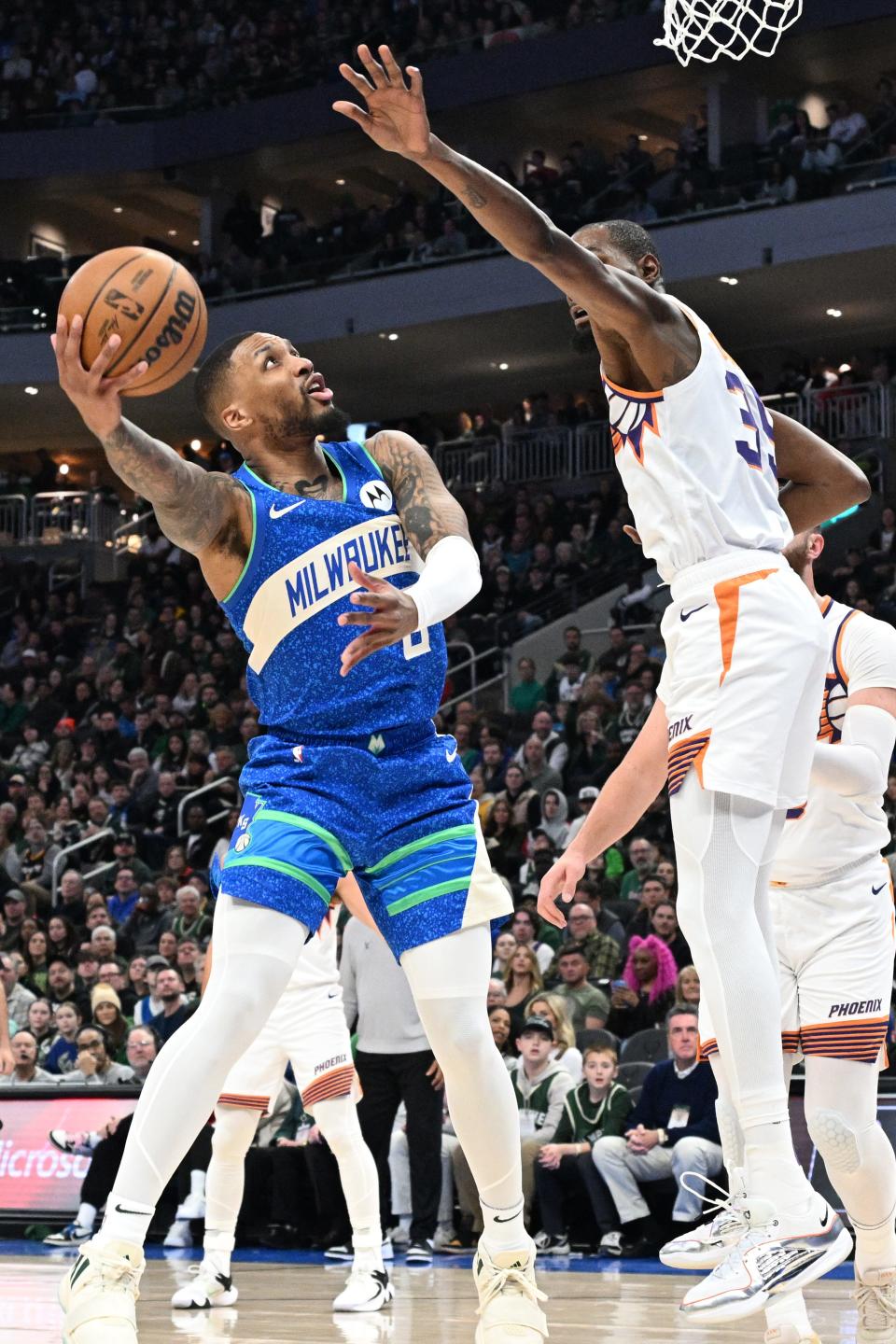 Milwaukee Bucks guard Damian Lillard (0) drives to the basket against Phoenix Suns forward Kevin Durant (35) in the first half at Fiserv Forum on March 17, 2024.