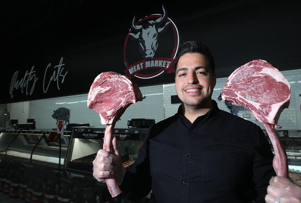 Fernando Alcauter, owner of Toro's Meat Market, holds two tomahawks of beef earlier this year. The business is sponsoring a tamale-eating contest at the Northland festival.