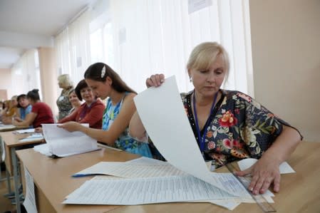 Members of a an electoral commission work at a polling station during a parliamentary election in Kiev