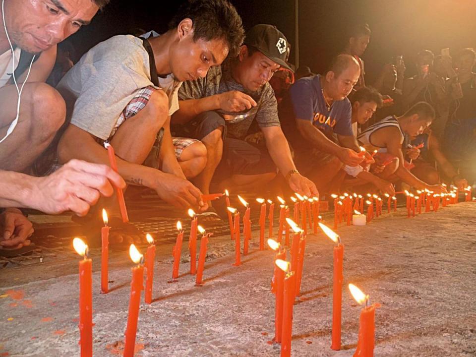 南方澳外籍漁工為死亡的6名同胞點蠟燭祈禱。（讀者提供）