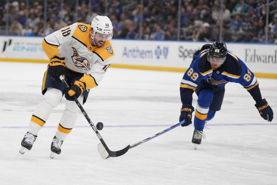 Nashville Predators' Liam Foudy (18) and St. Louis Blues' Pavel Buchnevich chase after a loose puck during the third period of an NHL hockey game on Friday, Nov. 24, 2023, in St. Louis. (AP Photo/Jeff Roberson)