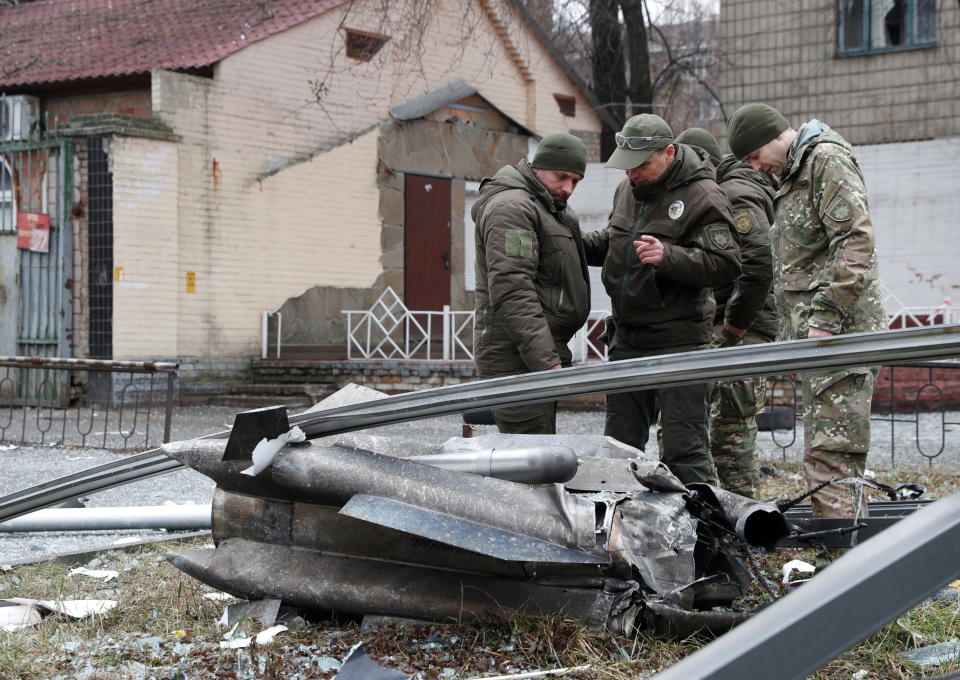 Police officers inspect the remains of a missile that fell in the street, after Russian President Vladimir Putin authorized a military operation in eastern Ukraine, in Kyiv, Ukraine February 24, 2022. REUTERS/Valentyn Ogirenko