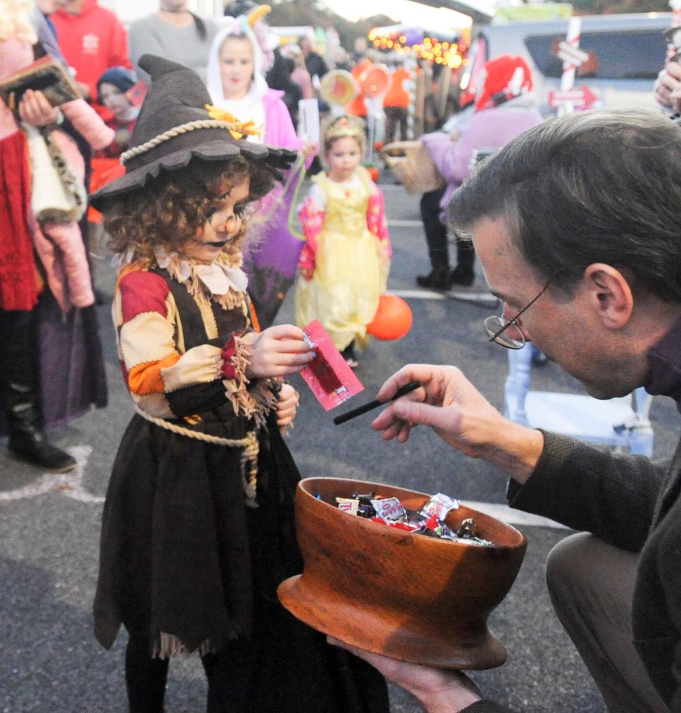 Then five-year-old Abigale Gross of Falmouth chooses her treat from Eric Jensen of Falmouth during the Trunk or Treat at Cape Cod Church in East Falmouth in 2018.