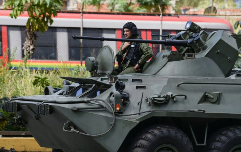 An armored tank from the Venezuelan army drives along a highway in Caracas as an operation to capture Oscar Perez, the Venezuelan helicopter pilot who dropped grenades on the Supreme Court last year during anti-government protests, is carried out on January 15, 2018