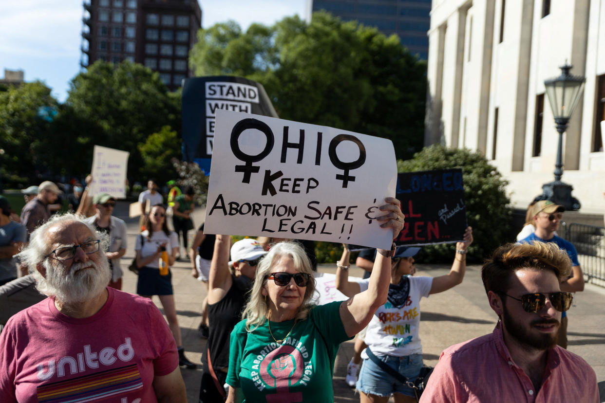 An abortion rights protester holds a sign saying, Ohio, Keep Abortion Safe & Legal!!