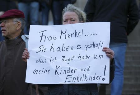 A woman holds up a placard reading 'Mrs Merkel you have achiedved that i'm afraid of the furture for my children and grandchildren' prior to a demonstration by anti-immigration right-wing movement PEGIDA (Patriotic Europeans Against the Islamisation of the West) in Cologne, Germany, January 9, 2016. REUTERS/Wolfgang Rattay