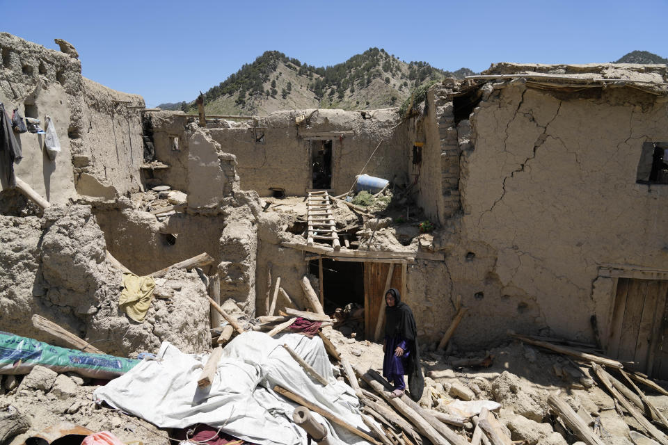 Afghan woman walks amid destruction after an earthquake in Gayan village, in Paktika province, Afghanistan, Friday June 24, 2022. A powerful earthquake struck a rugged, mountainous region of eastern Afghanistan early Wednesday, flattening stone and mud-brick homes in the country's deadliest quake in two decades, the state-run news agency reported. (AP Photo/Ebrahim Nooroozi)