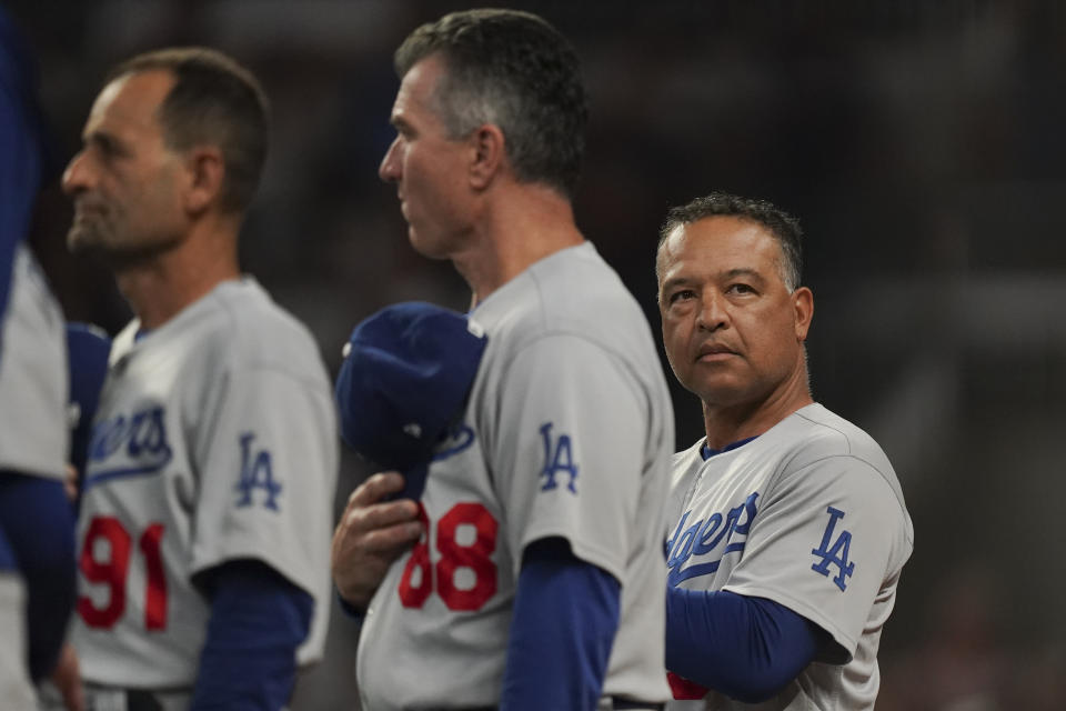 Los Angeles Dodgers manager Dave Roberts, right, waits for the playing of the national anthem before Game 6 of baseball's National League Championship Series against the Atlanta Braves Saturday, Oct. 23, 2021, in Atlanta. (AP Photo/Brynn Anderson)