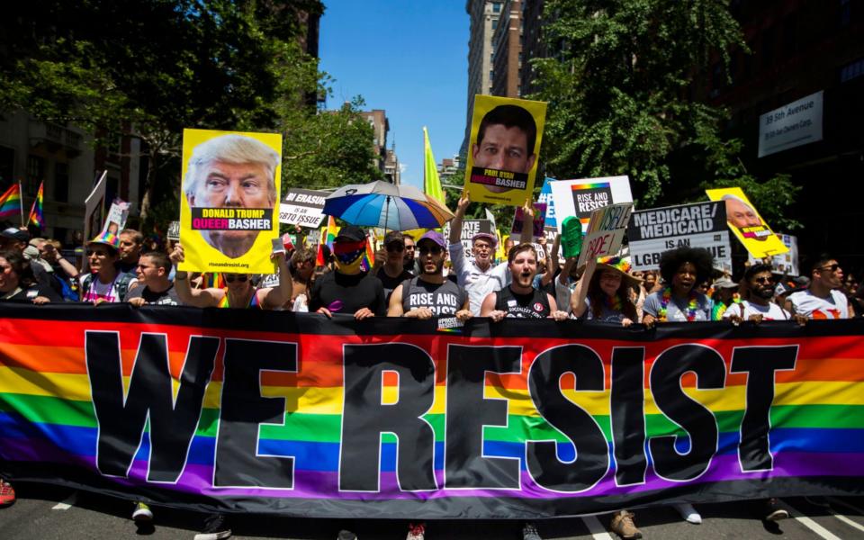 Members of Resist, a foundation that supports people's movements for justice and liberation. protest President Donald Trump and other politicians as they march during the New York City Pride Parade  - Credit: AP