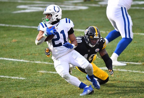 Running back Nyheim Hines #21 of the Indianapolis Colts runs with the ball as linebacker Tegray Scales #40 of the Pittsburgh Steelers tries for the tackle in the second quarter of their game at Heinz Field on December 27, 2020 in Pittsburgh, Pennsylvania.