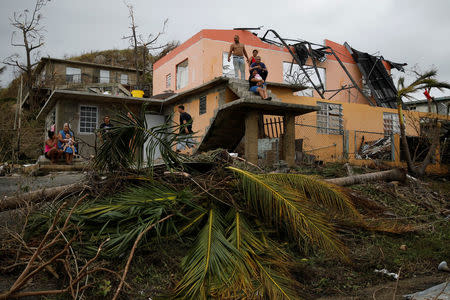 People rest outside a damaged house after the area was hit by Hurricane Maria in Yabucoa, Puerto Rico September 22, 2017. REUTERS/Carlos Garcia Rawlins