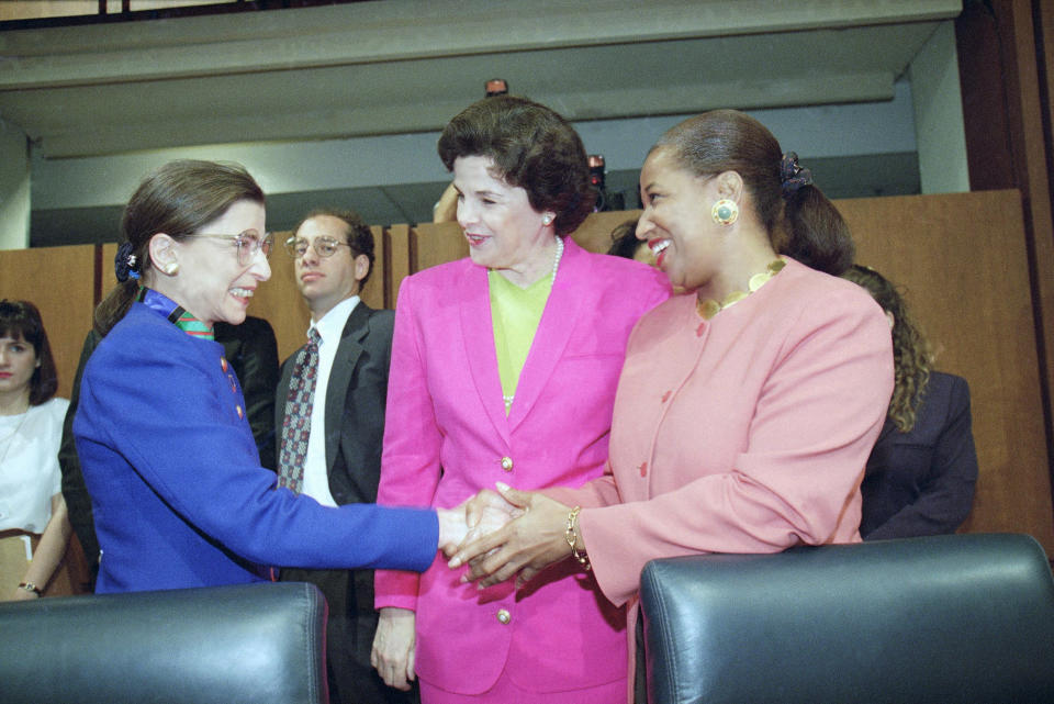 Supreme Court nominee Judge Ruth Bader Ginsburg, left, shakes hands with Sen. Carol Moseley-Braun, D-Ill., as Sen. Dianne Feinstein, D-Calif., looks on prior to Ginsburg’s confirmation hearing before the Senate Judiciary Committee on Capitol Hill (Photo: Doug Mills/AP)