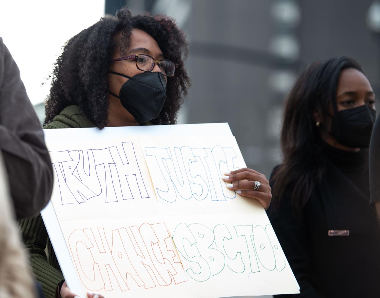 Korin Reid holds up a sign while listening to Hannah-Kate Williams in front of the Southern Baptist Convention building in Nashville, Monday, Feb. 21, 2022. 