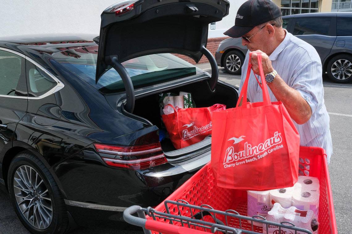 Neil Flynt of Calabash, N.C. loads his groceries in his car in reusable bags at Boulineau’s Foods Plus in North Myrtle Beach, S.C. The store is making a transition away from plastic bags to the more environmentally friendly paper and reusable tote bags but has struggled with the cost and supply of paper bags. The local grocery has given away over 100,000 reusable bags. July 6, 2022.