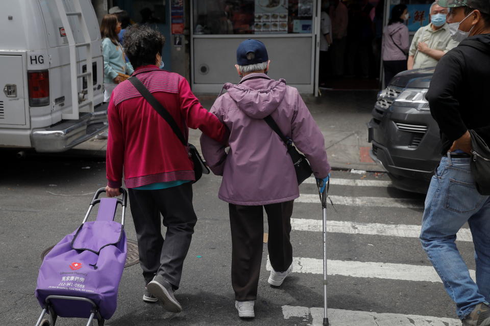 An elderly couple cross Bayard Street near the site of the May 31, 2021 unprovoked attack on an Asian person, a 55 year old woman, in Manhattan's Chinatown district in New York City, U.S. June 2, 2021. REUTERS/Mike Segar