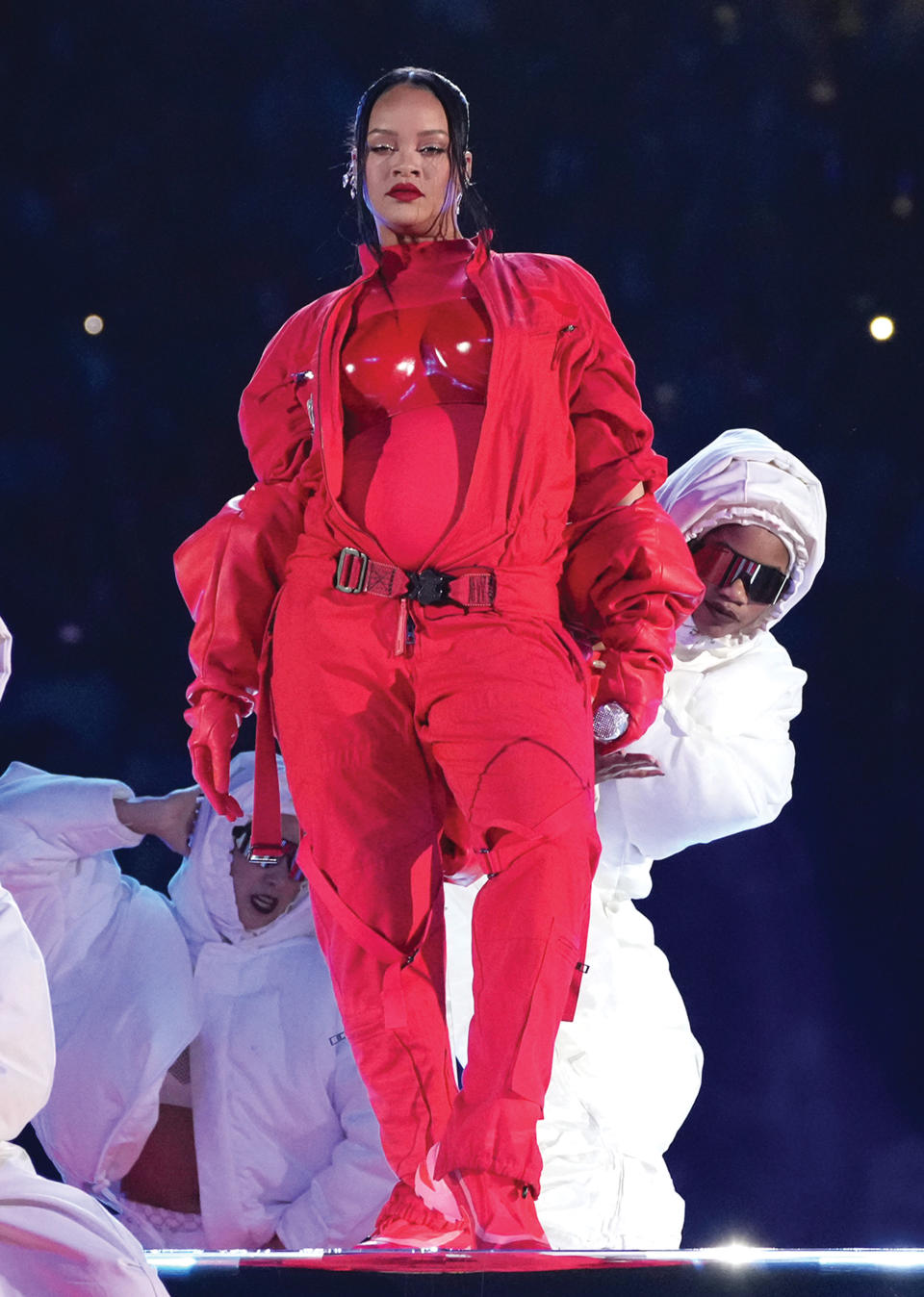 Rihanna’s Super Bowl halftime show look, built on a red Loewe catsuit, was envisioned with her stylist Jahleel Weaver and functioned as the most-watched pregnancy announcement in history with 118 million viewers.