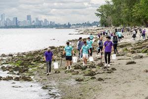 Los jugadores de Vancouver Whitecaps, de izquierda a derecha, Mathieu Campagna, Sebastian Berhalter y Alessandro Schopf, fotografiados junto con el equipo TELUS, recogen desechos en Spanish Banks Beach.