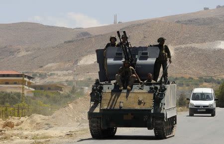 Lebanese army soldiers sit atop of an armoured carrier at the entrance of the Sunni Muslim border town of Arsal, in eastern Bekaa Valley August 5, 2014. REUTERS/Hassan Abdallah