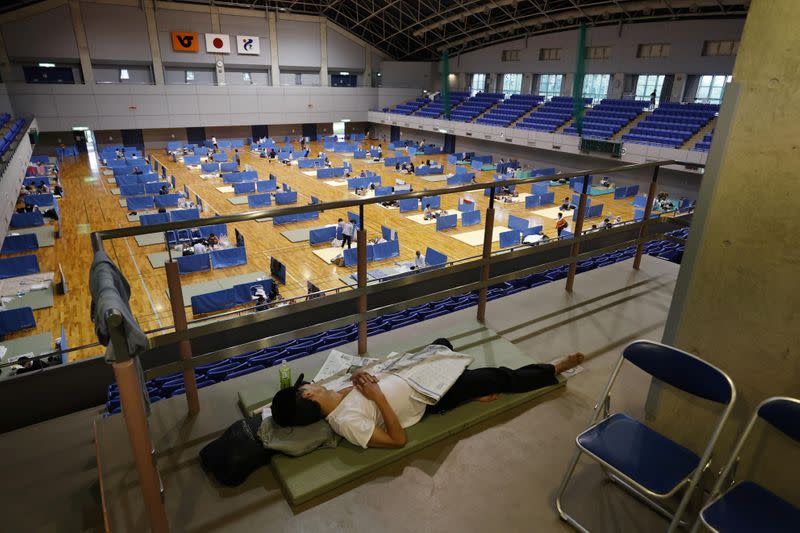 A man lies on a mattress at a shelter for evacuees of torrential rain in Hitoyoshi, Kumamoto prefecture