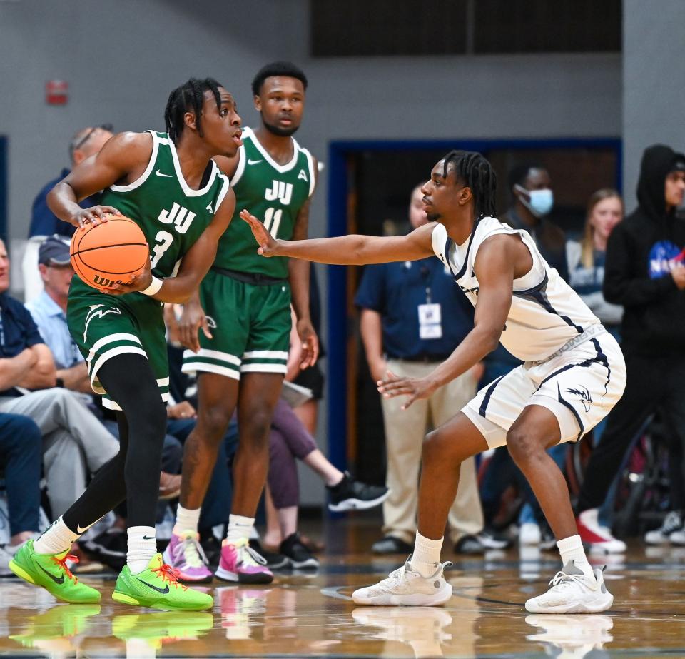 Jacksonville University guard Kevion Nolan looks for an opening over North Florida's Jarius Hicklen during a River City Rumble game in 2022 at UNF Arena.