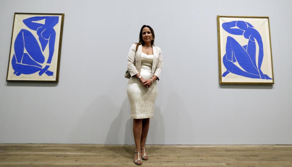 Sophie Matisse, the great-granddaughter of Henri Matisse, poses alongside his work 'Blue Nude III 1952', left, and Blue Nude II 1952', right, at The Tate Modern in London, Monday, April 14, 2014. The artworks are part of the 'Henri Matisse: The Cut-Outs' exhibition that runs at the gallery from April 17 until Sept. 7, 2014.(AP Photo/Kirsty Wigglesworth)