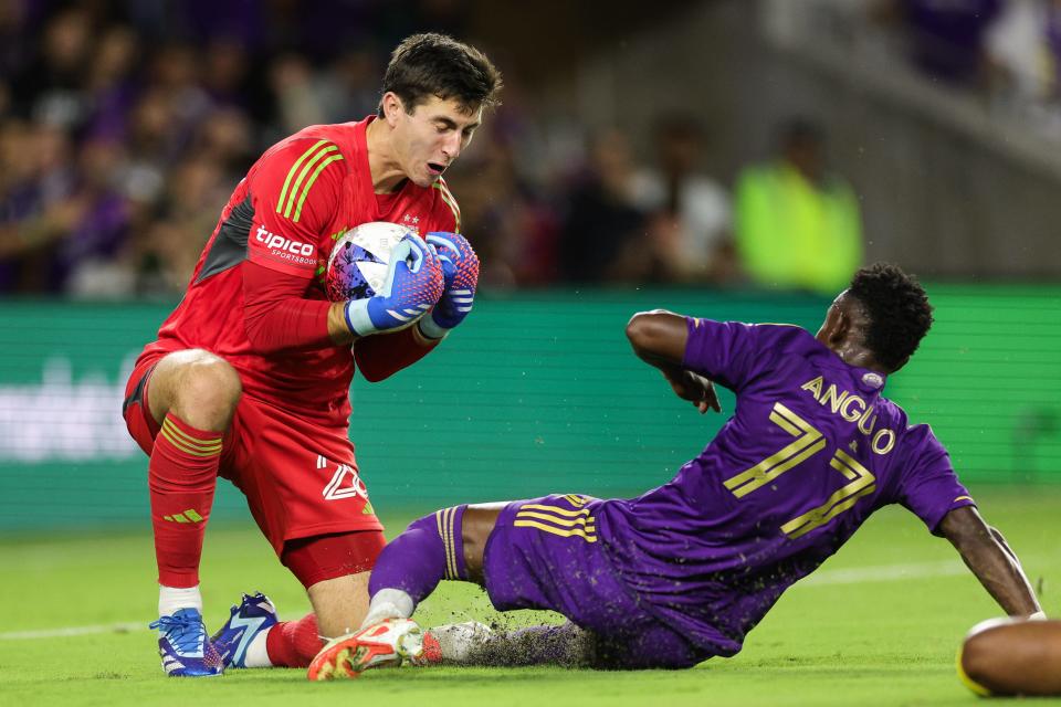 Nov 25, 2023; Orlando, Florida, USA; Columbus Crew goalkeeper Patrick Schulte (28) claims the ball as Orlando City forward Iván Angulo (77) slides in during the first half in a MLS Cup Eastern Conference Semifinal match at Exploria Stadium. Mandatory Credit: Nathan Ray Seebeck-USA TODAY Sports