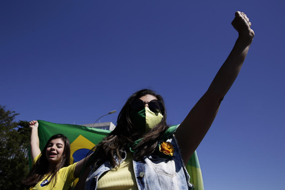 Supporters of Brazil's President Jair Bolsonaro shout slogans during a protest against former Minister of Justice Sergio Moro and the Supreme Court, in front of the Planalto presidential palace, in Brasilia, Brazil, Sunday, May 3, 2020. (AP Photo/Eraldo Peres)