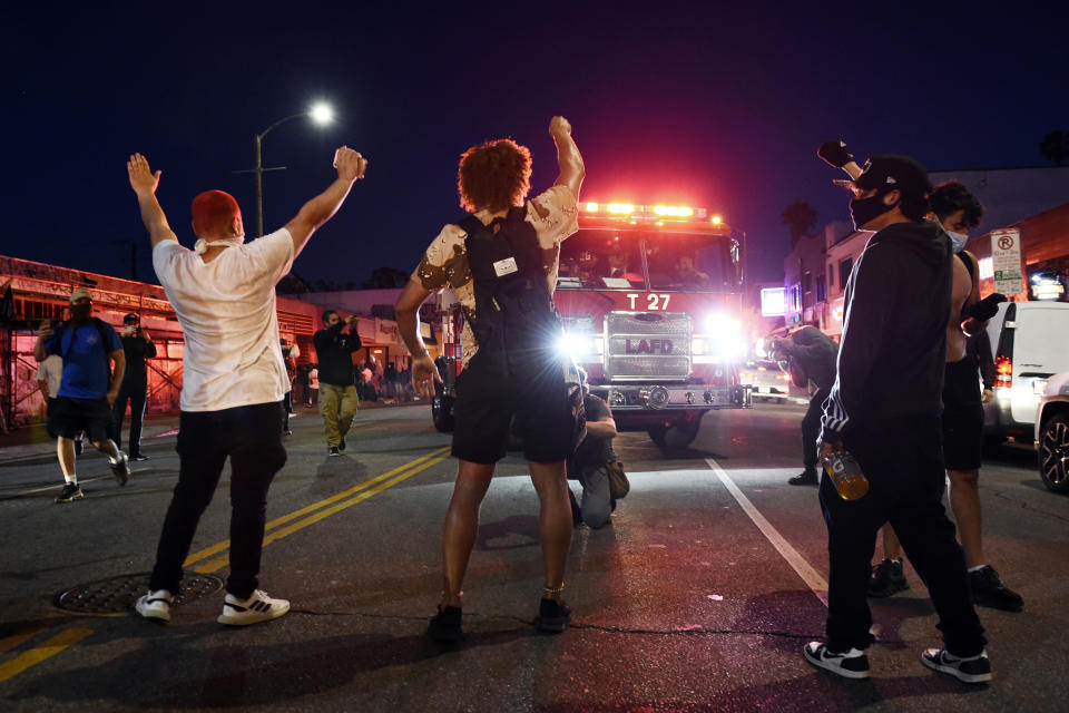 Manifestantes bloqueando el paso a un camión de bomberos de Los Ángeles, durante disturbios en Melrose Avenue, el sábado 30 de mayo de 2020 en Los Ángeles. (AP Foto/Chris Pizzello)