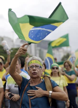 A demonstrator waves a Brazilian national flag during a protest against Brazil's President Dilma Rousseff, part of nationwide protests calling for her impeachment, at Copacabana beach in Rio de Janeiro, Brazil, March 13, 2016. REUTERS/Ricardo Moraes