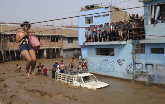 <p>Una mujer es sacada de la inundación mediante una tirolesa improvisada en Lima, 17 de marzo de 2017. Las intensas lluvias, desbordes de ríos, avalanchas de lodo e inundaciones provocadas por el fenómeno climático El Niño Costero son peores en algunas zonas que hace dos décadas, afectan a más de la mitad de Perú y mataron a 72 peruanos desde inicio de año. AP Foto/Martin Mejia </p>