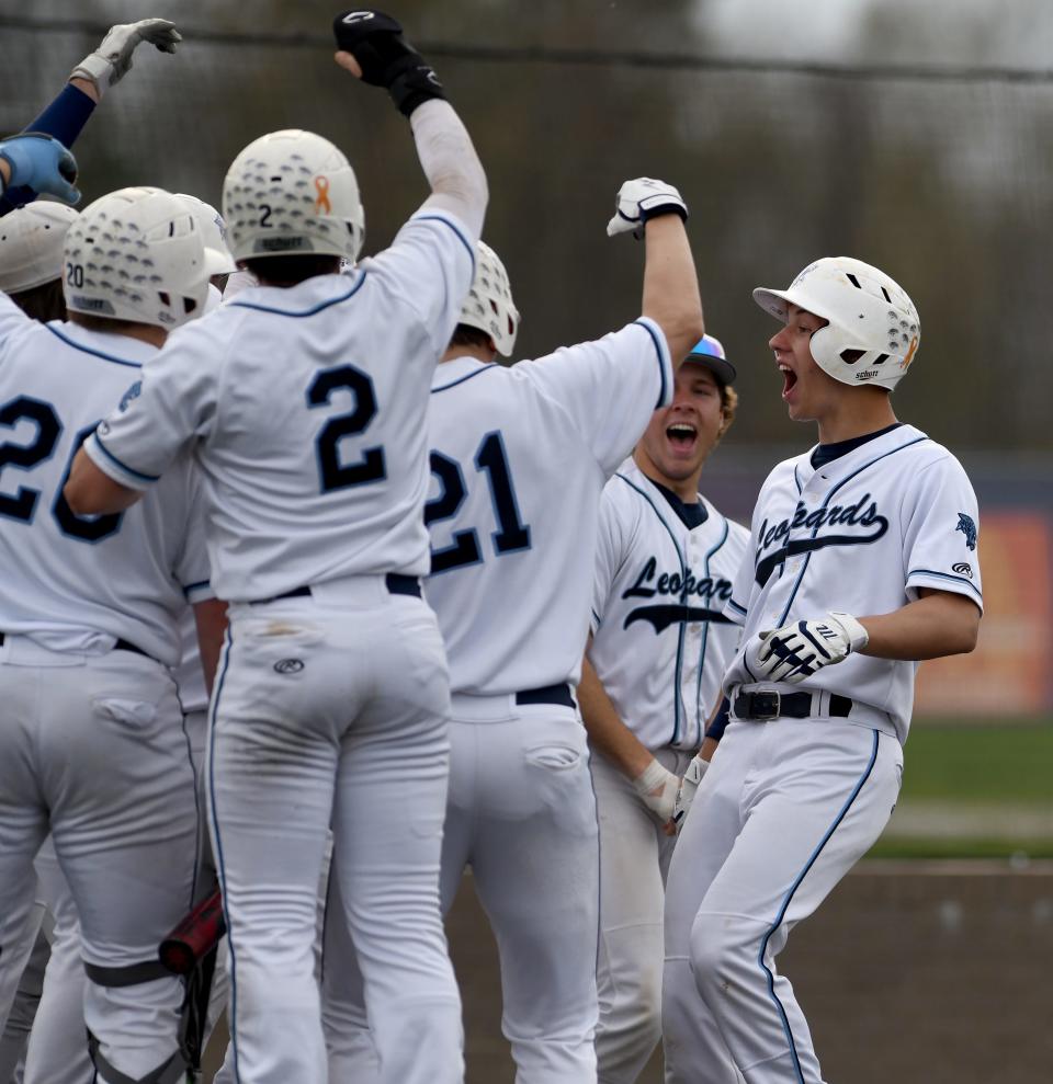 Louisville's Charlie Roberts is greeted by his team after a first inning home run against Hoover at Louisville.  Friday,  April 14, 2023.