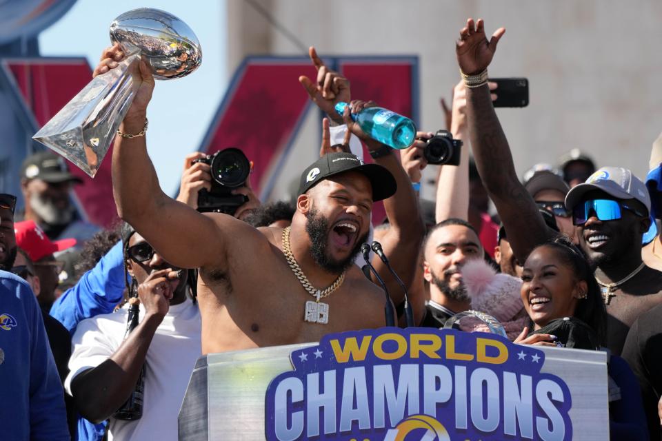 Aaron Donald holds the Vince Lombardi Trophy during the Rams' Super Bowl 56 championship rally at the Los Angeles Memorial Coliseum.