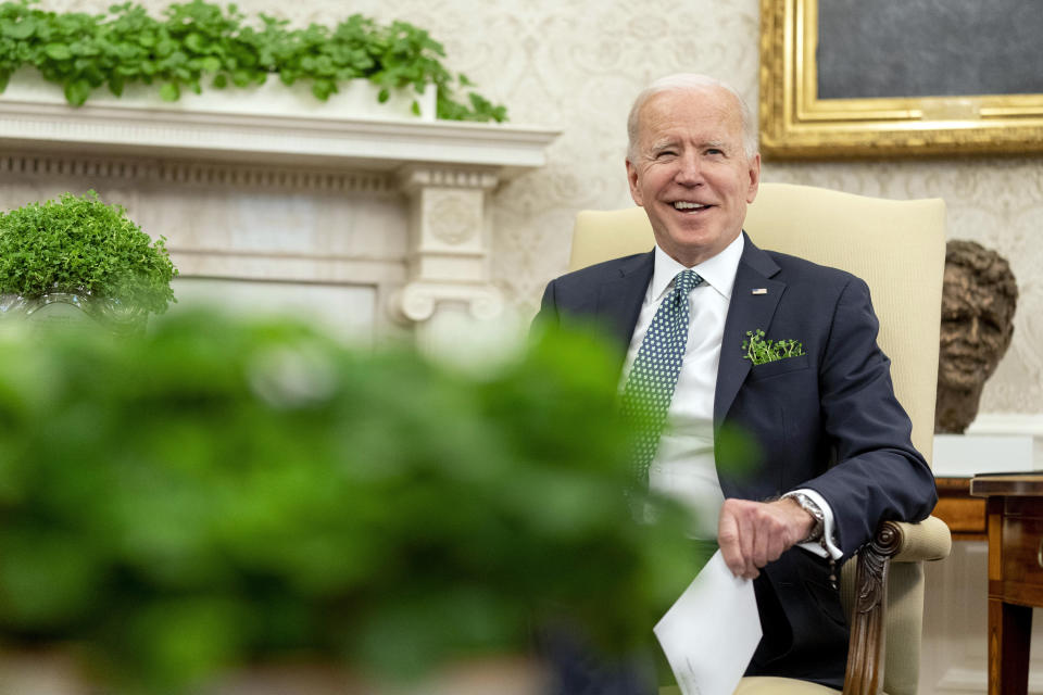 President Joe Biden sits next to a bowl of Irish shamrocks, left, as he speaks during a virtual meeting with Ireland's Prime Minister Micheal Martin on St. Patrick's Day, in the Oval Office of the White House, Wednesday, March 17, 2021, in Washington. (AP Photo/Andrew Harnik)