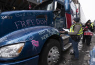 Police speak with a driver as they distribute notices to protesters, Wednesday, Feb. 16, 2022 in Ottawa. Ottawa’s police chief was ousted Tuesday amid criticism of his inaction against the trucker protests that have paralyzed Canada's capital for over two weeks, while the number of blockades maintained by demonstrators at the U.S. border dropped to just one. (Adrian Wyld /The Canadian Press via AP)