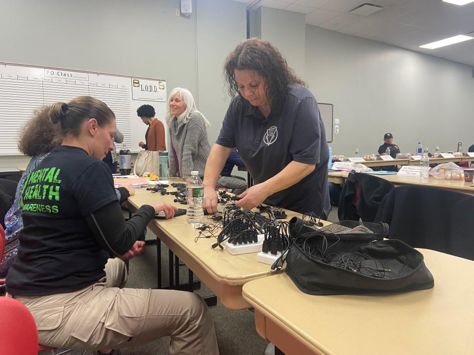 On Monday, March 6, 2023, Amie Del Sordo of CarePlus and Sgt. Sara Toro with the Bergen County Sheriff's Office, untangle headphones for a CIT training session to show students how it feels to hear voices in their heads.