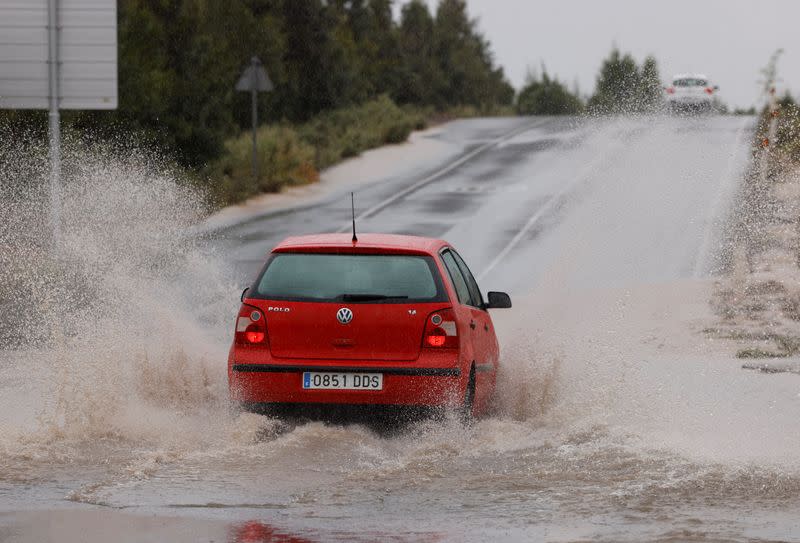 A vehicle passes through a large puddle of water caused by rain by the tropical storm Hermine, in Playa del Ingles