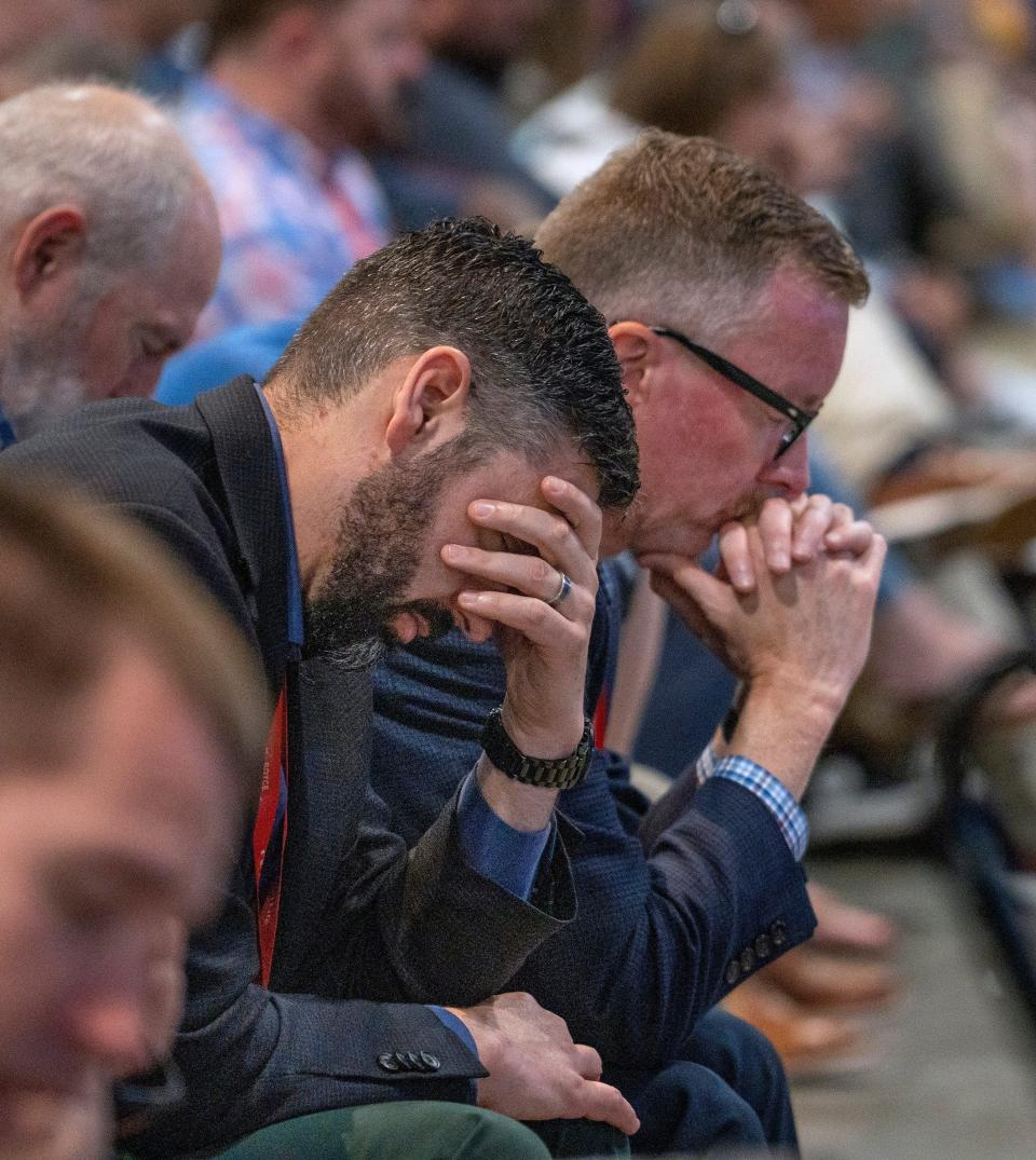 People bow their heads in prayer during the Southern Baptist Convention on June 11 at the Indiana Convention Center.