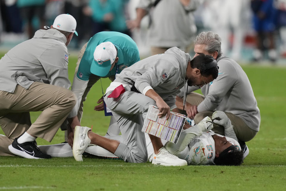 Miami Dolphins head coach Mike McDaniel checks on linebacker Cameron Goode (53) as he lies injured on the field during the second half of an NFL football game against the Buffalo Bills, Sunday, Jan. 7, 2024, in Miami Gardens, Fla. (AP Photo/Lynne Sladky)