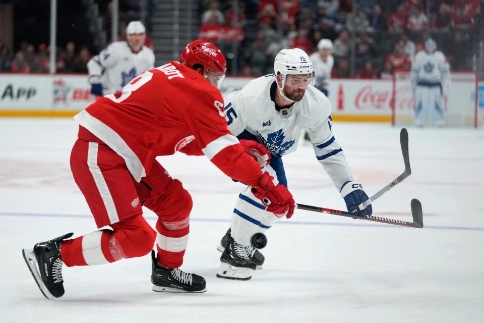 Detroit Red Wings defenseman Ben Chiarot (8) tries to stop the puck from Toronto Maple Leafs center Logan Shaw (15) in the first period at Little Caesars Arena in Detroit on Saturday, Oct. 7, 2023.