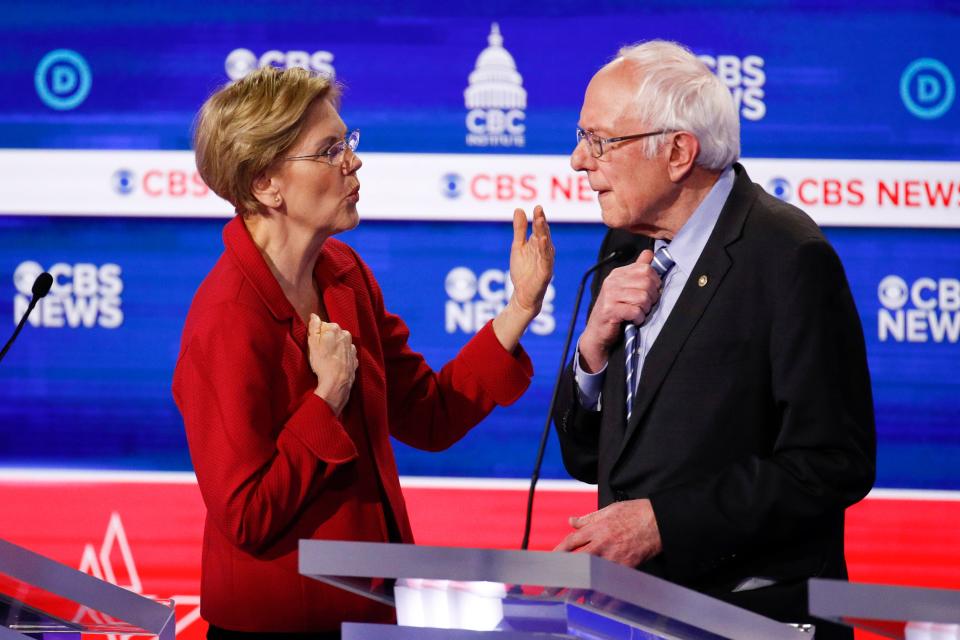 Sen. Elizabeth Warren of Massachusetts talks with Sen. Bernie Sanders of Vermont on stage after the Democratic presidential primary debate in Charleston, S.C., on Feb. 25, 2020.
