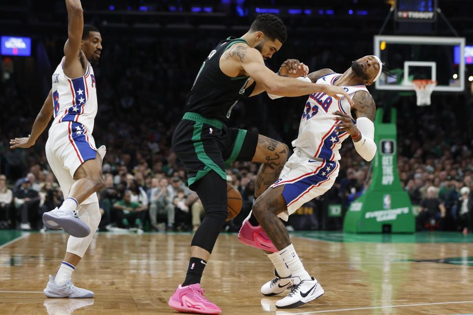 Boston Celtics' Jayson Tatum (0) fouls Philadelphia 76ers' Robert Covington (33) during the second half of an NBA basketball game, Friday, Dec. 1, 2023, in Boston. (AP Photo/Michael Dwyer)