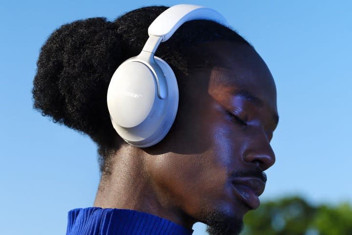 Man wearing Bose QuietComfort Ultra Headphones in white.