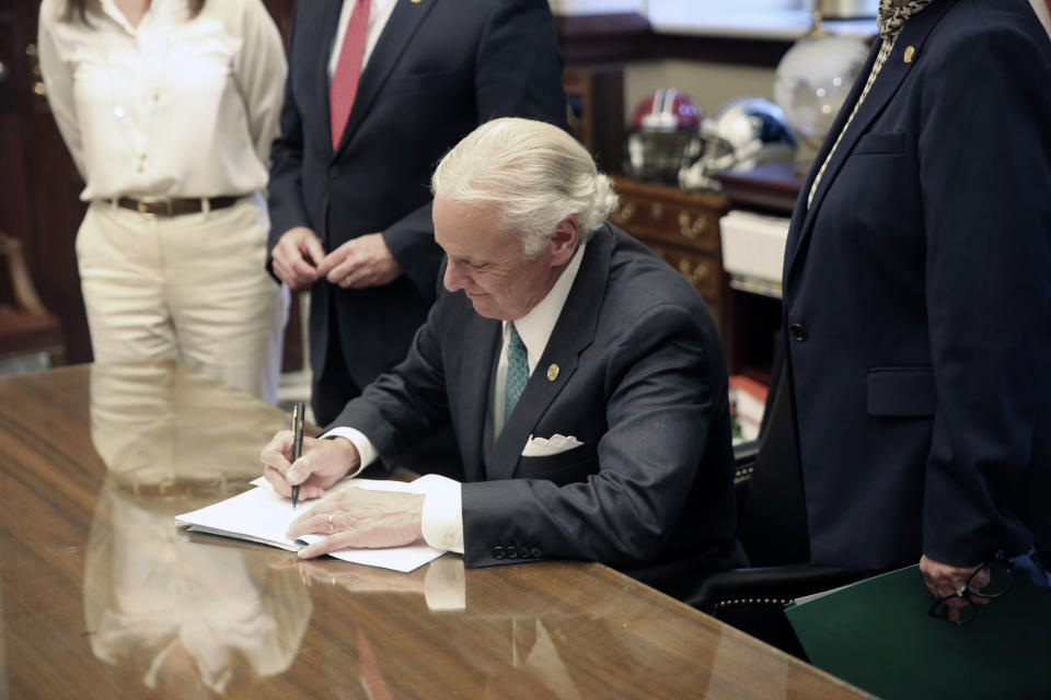 South Carolina Gov. Henry McMaster signs a bill requiring schools to provide in-person classes five days a week starting April 26 and for next school year on Thursday, April 22, 2021, in Columbia, S.C. The bill also requires school districts to pay teachers extra if they have to teach both in person and online. (AP Photo/Jeffrey Collins)