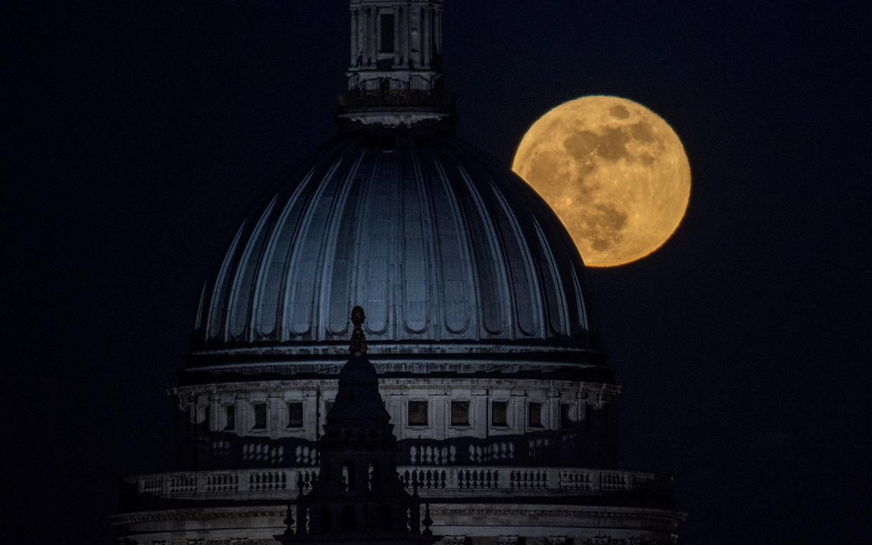 The moon rises behind St Paul's, London - Getty Images