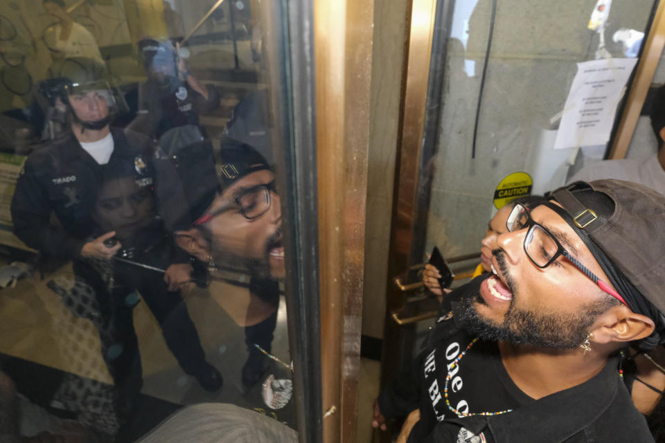 Community members confront with police officers during a protest to condemn the racist comments made in a 2021 at the City Hall Tuesday October 18, 2022 in Los Angeles. / Credit: Ringo Chiu / AP