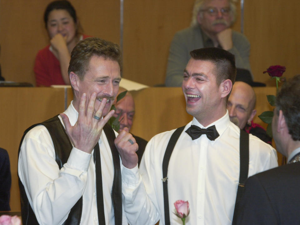 Frank Wittebrood, left, and Peter Wittebrood-Lemke, show their tattooed rings to Amsterdam mayor Job Cohen, right, after exchanging vows at Amsterdam's City Hall early Sunday, April 1, 2001. The pair was among four couples to get married under a new law which took effect April 1 and is the world's first such law allowing same-sex marriages with equal rights. (AP Photo/Peter Dejong)