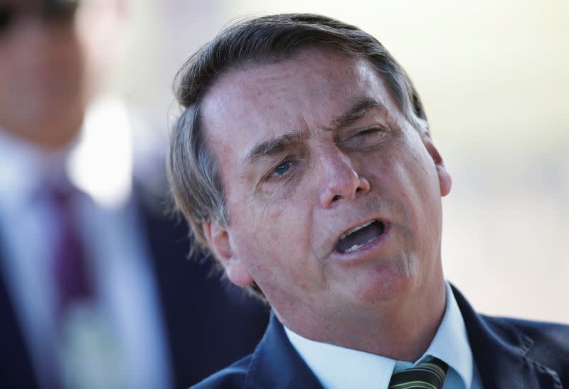 Brazil's President Jair Bolsonaro reacts after asked by journalists as he leaves at Alvorada Palace, amid coronavirus disease (COVID-19) outbreak, in Brasilia